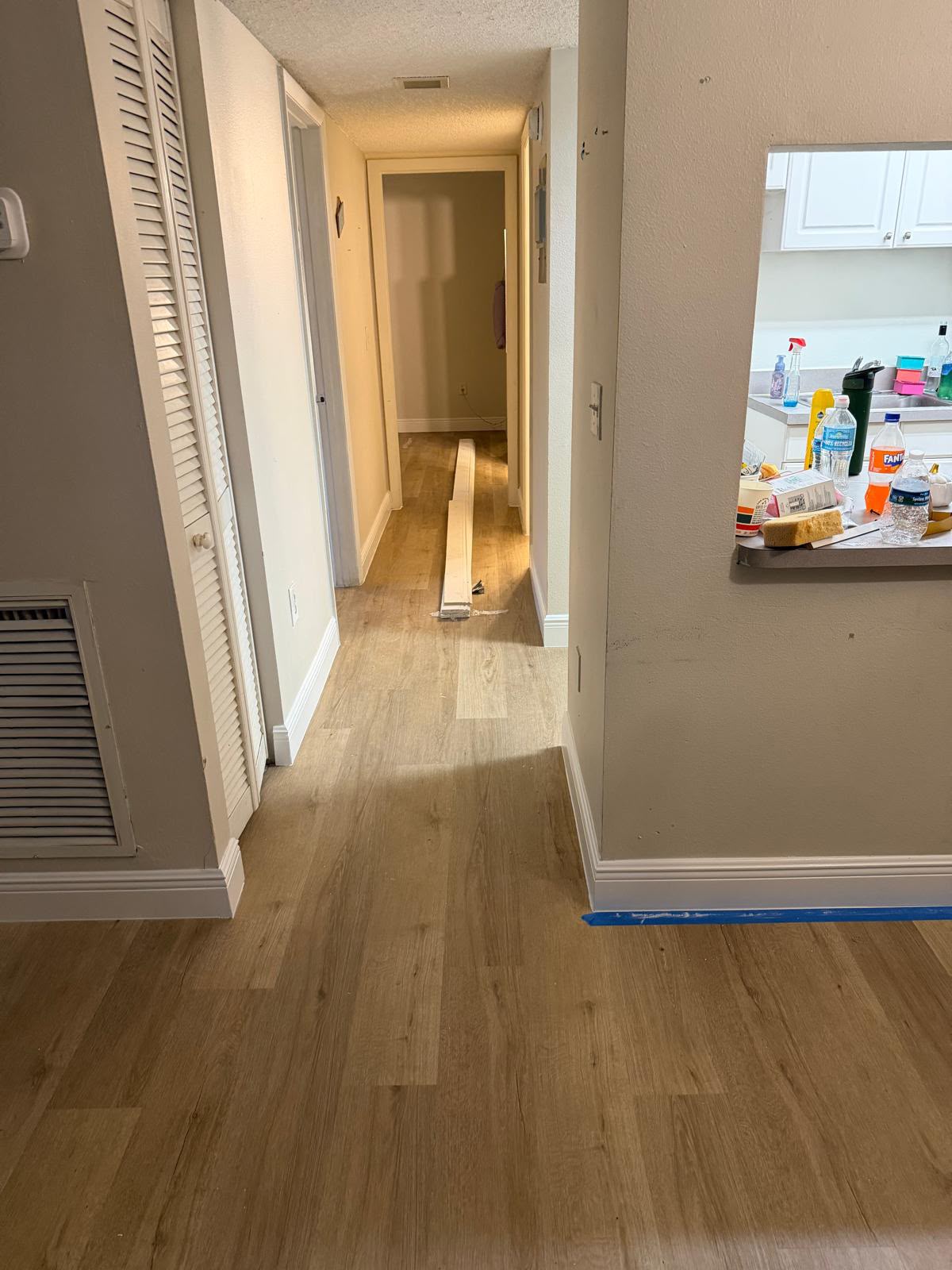 Hallway with new wood-look plank flooring and freshly painted trim