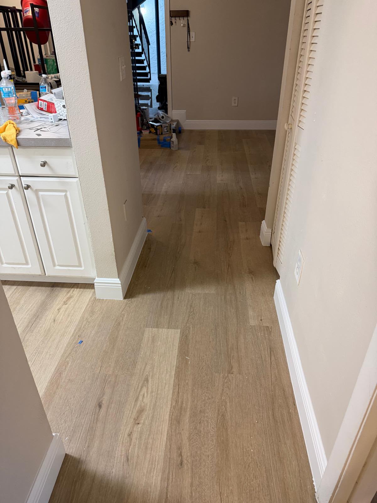 Open living area with new wood-look plank flooring and crisp white baseboards